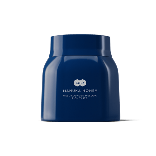 1.1lb blue jar of Manuka honey on a white background.