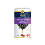 A box of Mânuka Health Mânuka Honey Drops in blackcurrant flavour, featuring a white and purple design with an illustration of blackcurrant grapes and a honey drop.