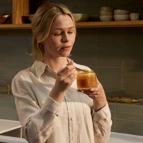 Woman holding Manuka Health's Reserve MGO 1000+ glass jar. 